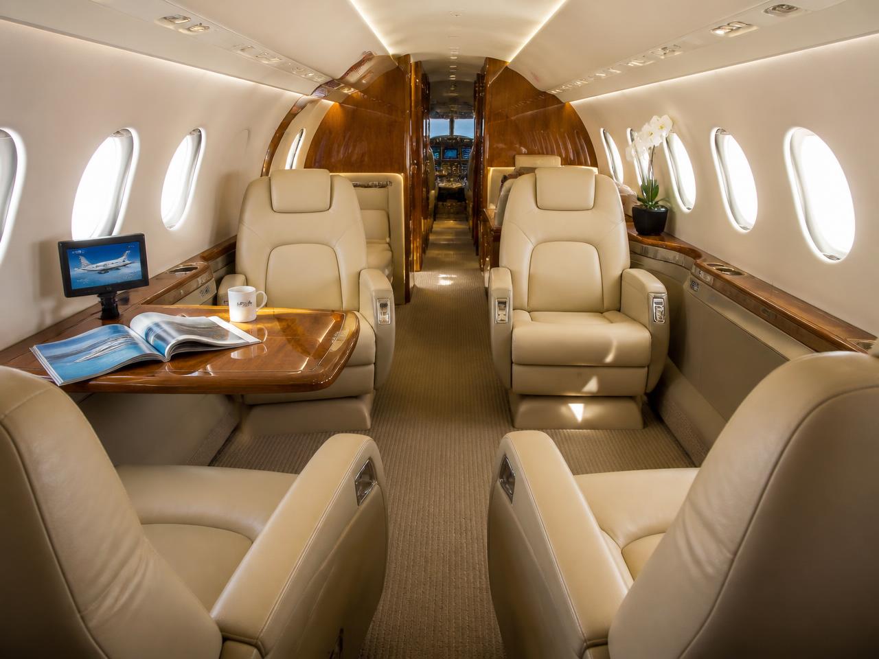 Hawker 900XP interior cabin with cream leather seating and wood veneer